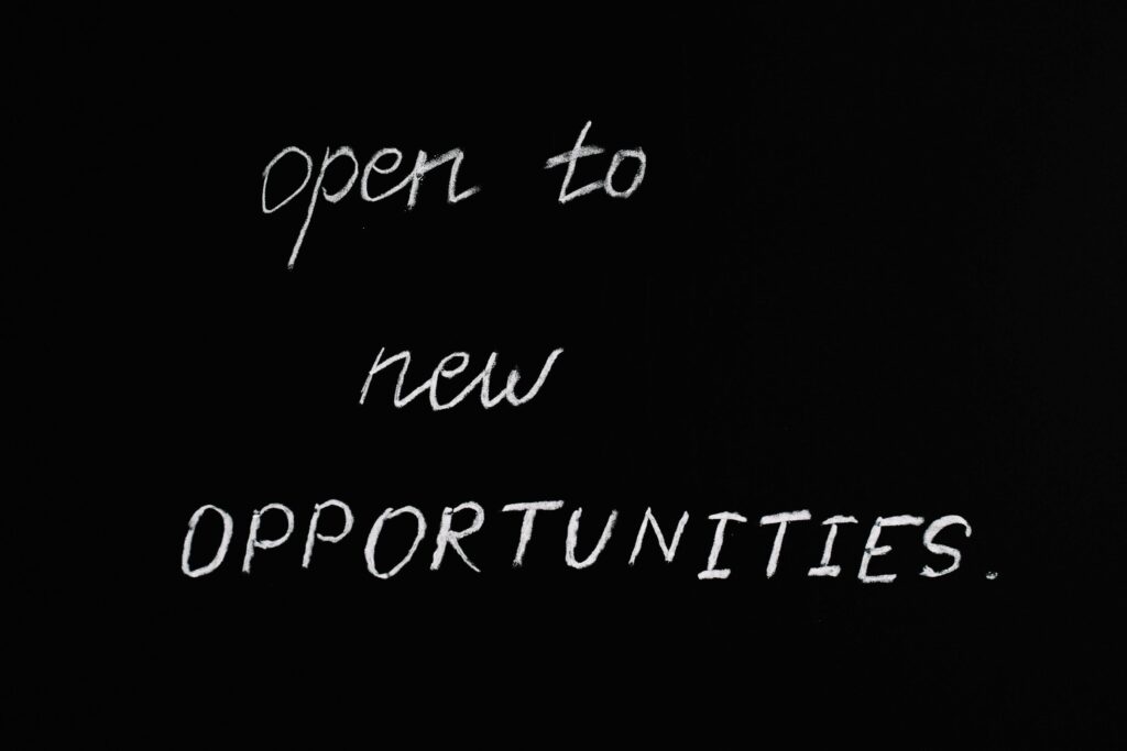 Fond d'ardoise avec le message 'open to new opportunities' écrit à la craie blanche, symbolisant l'ouverture à de nouvelles opportunités professionnelles exprimé dans la lettre de motivation