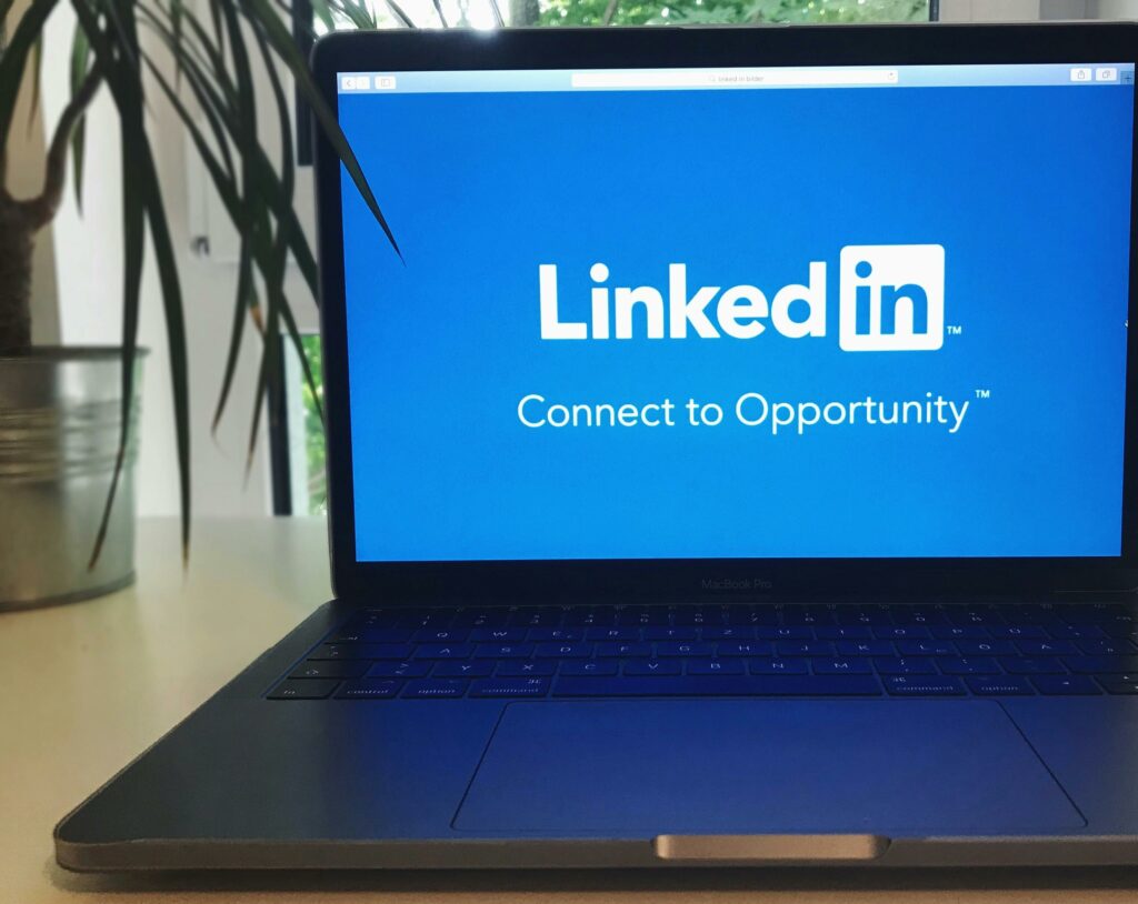 Ordinateur affichant le logo LinkedIn avec le slogan 'Connect to Opportunity', reflétant l'importance d'un profil optimisé avant de postuler à des offres d'emploi